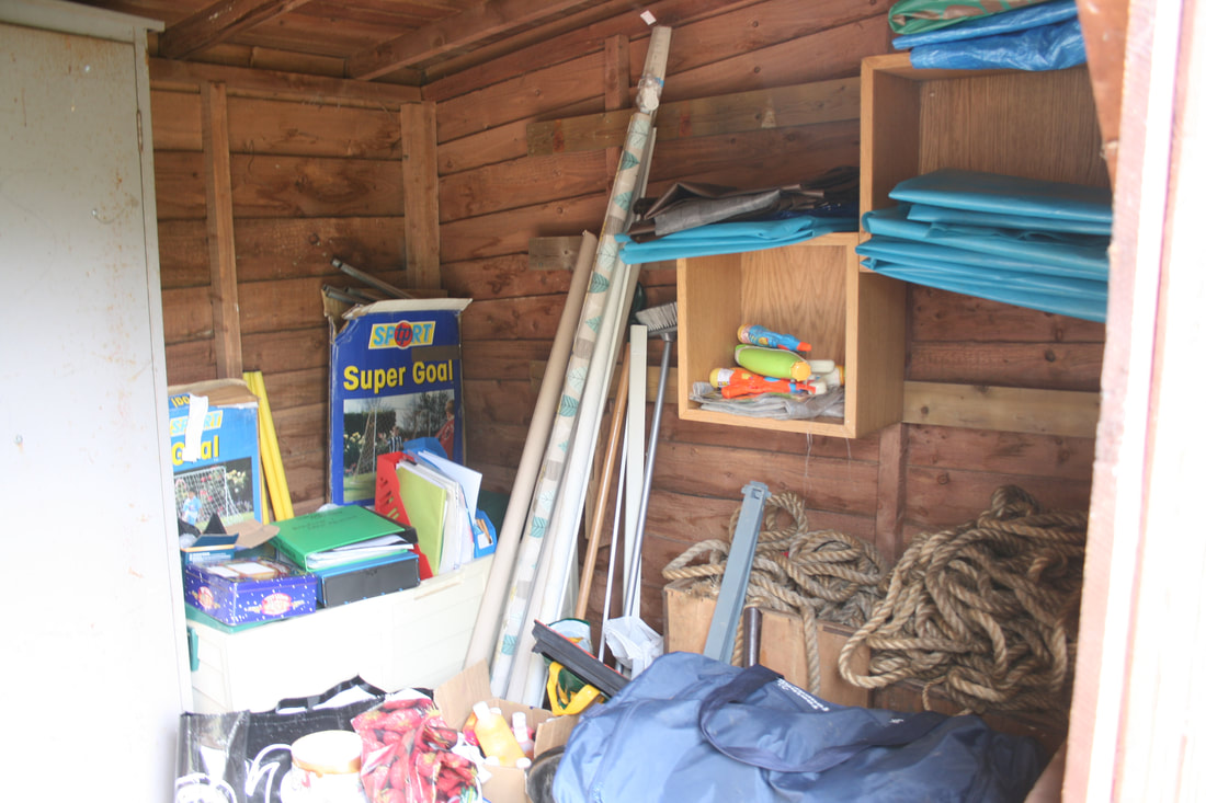 The interior of the smallwood hut with various games equipment, groundsheets and rope.